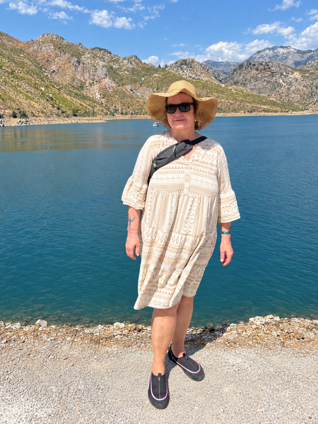 Sylvia wearing a sun hat beside a lake